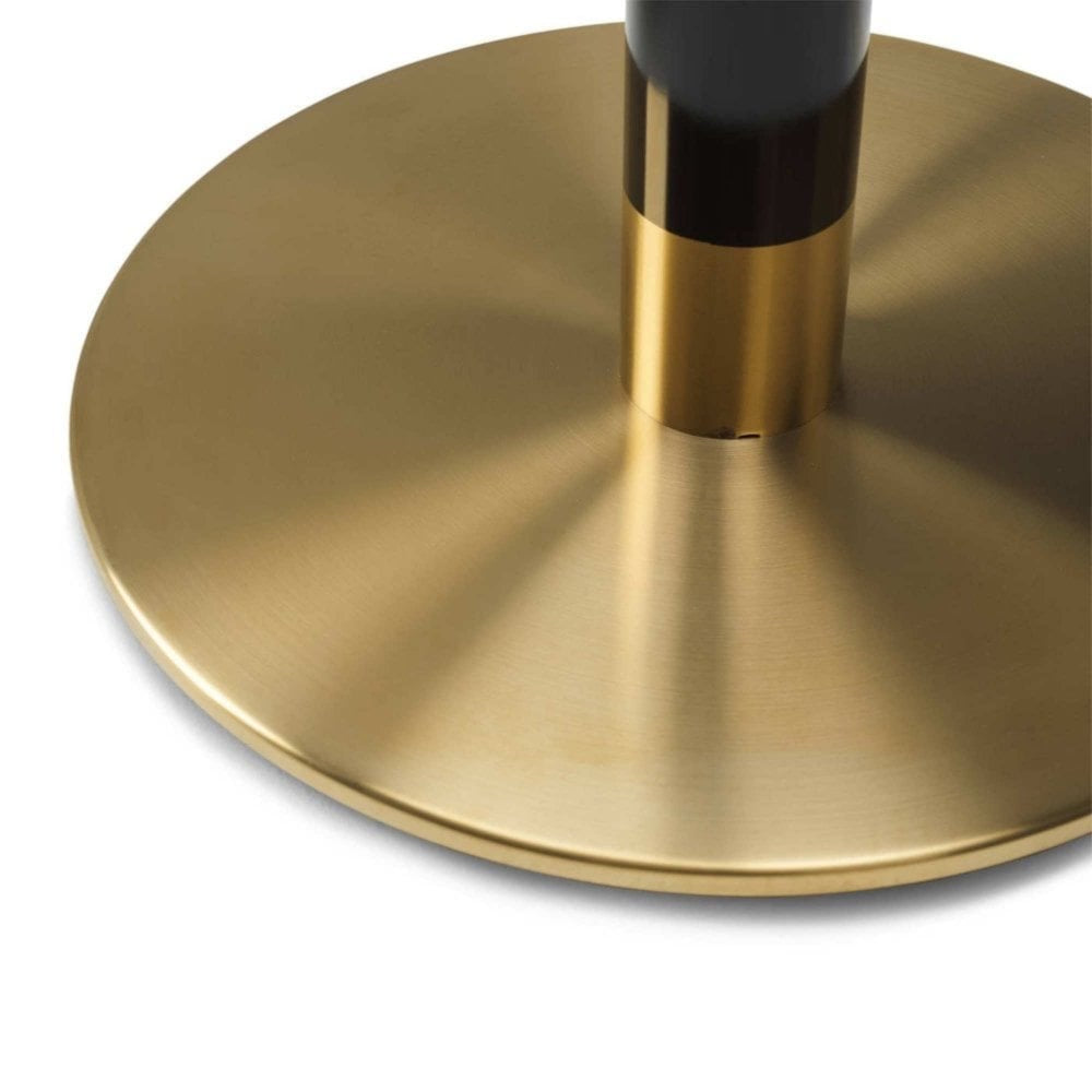 Close-up of the Cava Round Black and Gold Table Base - Large, featuring a cylindrical black and gold column attached to a large, round brushed brass base that casts soft reflections on its metallic surface.