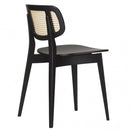 Switch The Gordona Black Rattan Effect Side Chair features a modern black beechwood frame, angled rear legs, a curved backrest with a woven cane insert, and a smooth contoured seat, displayed from a rear diagonal view. 2 image