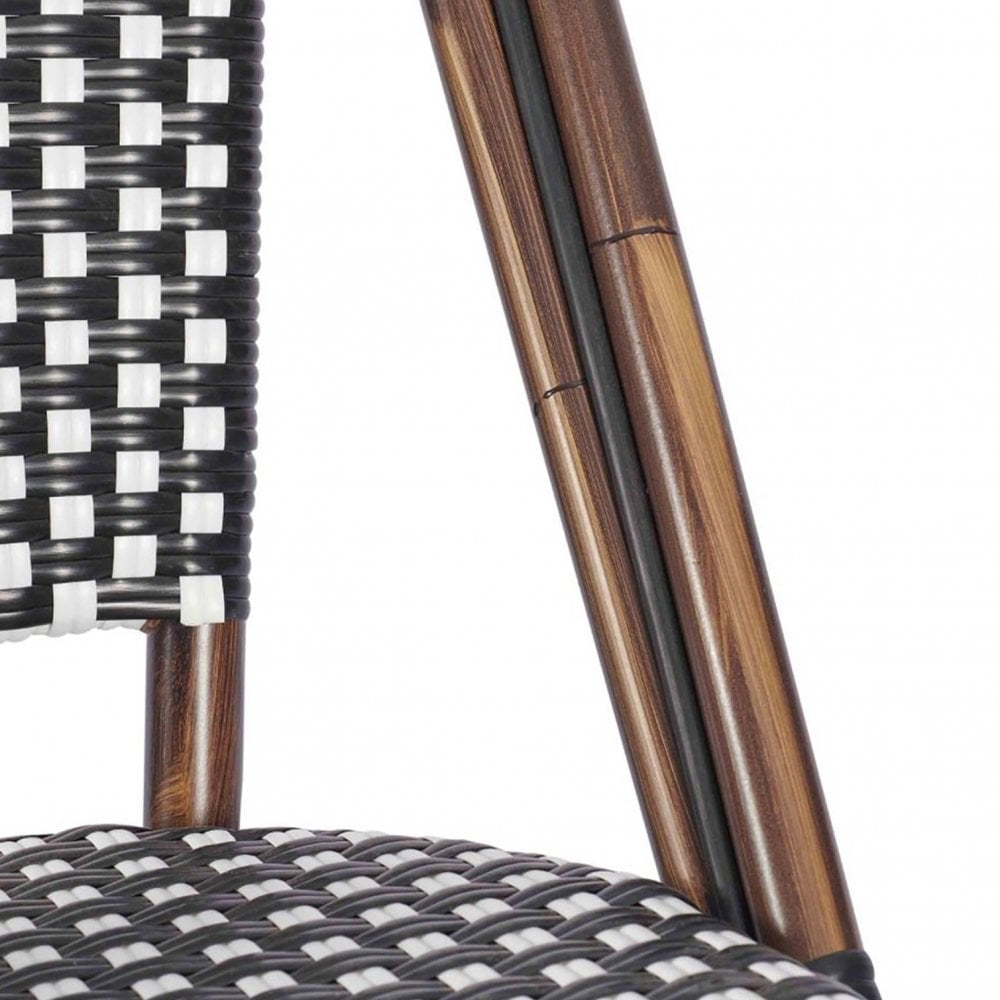 Close-up of the Carcassonne Bistro Outdoor Stacking Side Chair, featuring a black and white woven rattan seat and backrest, wooden legs, and an aluminum frame. Its checkered design gives this stackable chair a modern outdoor look.