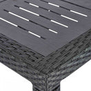 Switch Close-up of the Geneva Outdoor Stacking Dining Table featuring a rectangular, wood-textured slatted top with a woven rattan-style border and sturdy leg. Ideal for stylish al fresco dining. 2 image