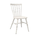 Switch The Spin Retro Outdoor Stacking Side Chair features a white spindle back, angled legs, and a distressed vintage finish. Its simple, classic look offers timeless style for contemporary outdoor dining spaces. Shown here on a plain white background. 3 image