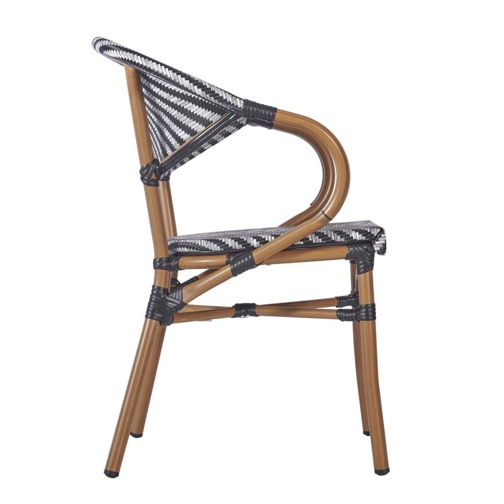 The Montpellier Bistro Outdoor Stacking Rattan Armchair features a curved bamboo-look frame and a black-and-white chevron woven seat and backrest—ideal as stylish furniture for a pub garden.