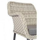 Switch The Bremen Outdoor Stacking Armchair features a beige wicker frame, woven backrest and armrests, gray seat cushion, and black legs on a white background. Perfect as commercial outdoor furniture for stylish seating. 3 image