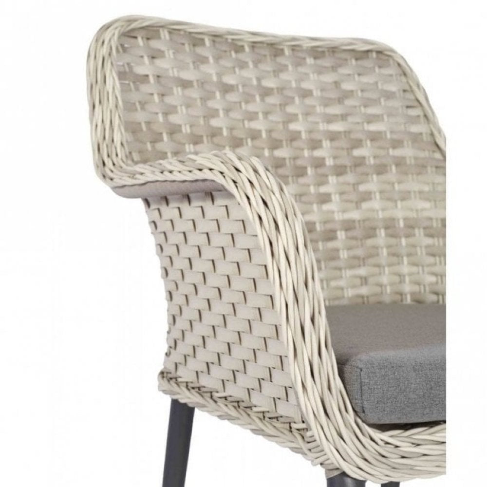 The Bremen Outdoor Stacking Armchair features a beige wicker frame, woven backrest and armrests, gray seat cushion, and black legs on a white background. Perfect as commercial outdoor furniture for stylish seating.