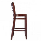 Switch Side view of the Devon Wooden Bar Stool in walnut, featuring a solid beech build, ladder-style backrest, and four legs with horizontal supports. Its simple, classic design makes it perfect for use as restaurant furniture. 2 image