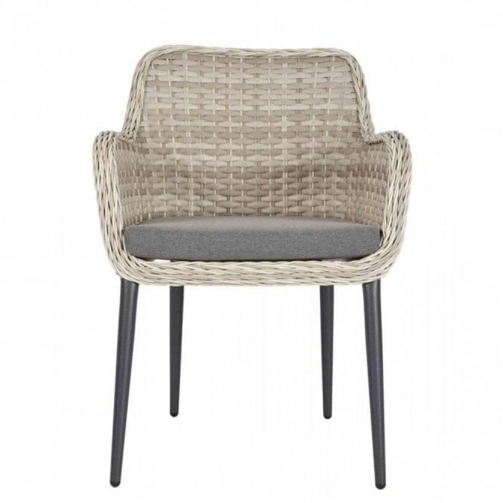 The Bremen Outdoor Stacking Armchair features a light beige woven wicker frame, gray cushioned seat, and four slim black legs—ideal for commercial outdoor spaces—displayed against a plain white background.