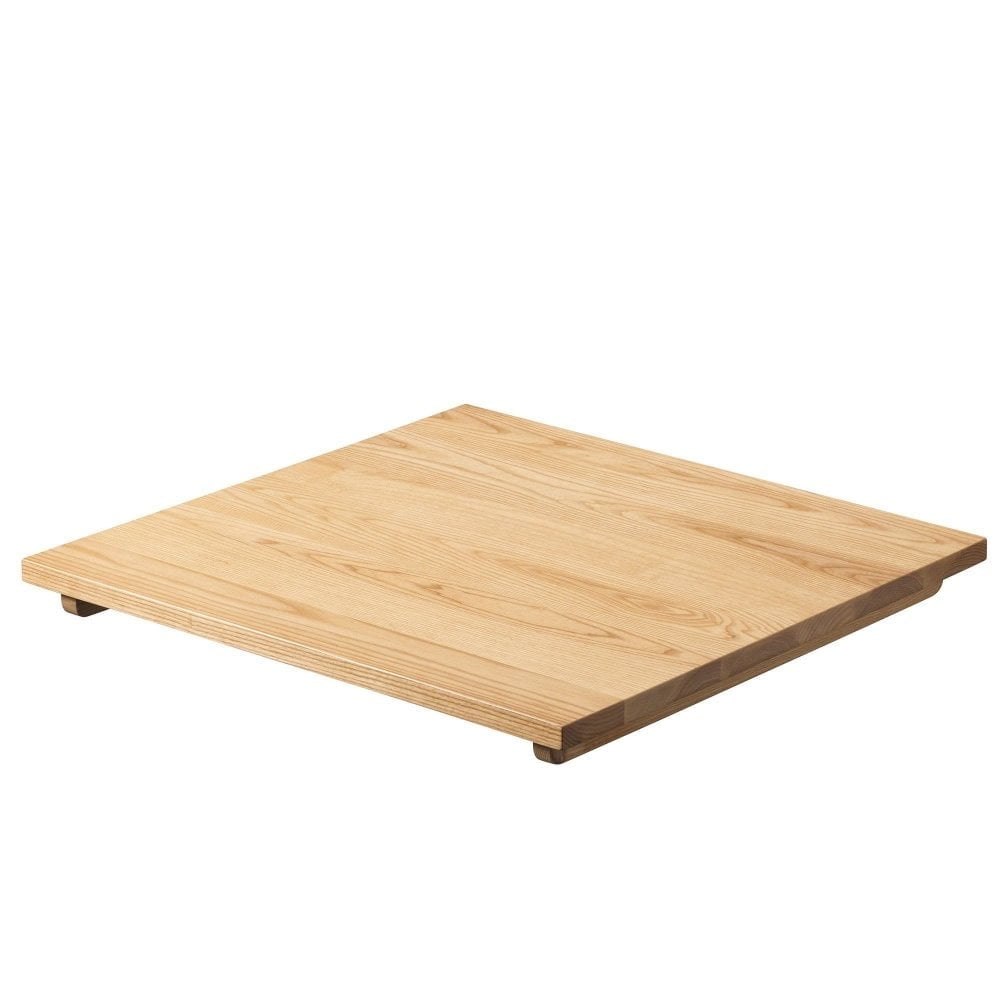 The Serranto Oak Stain Solid Ash Restaurant Table Top (25mm) features a flat, square profile with a natural light wood grain finish and rests on small feet at each corner for a modern, elegant look.