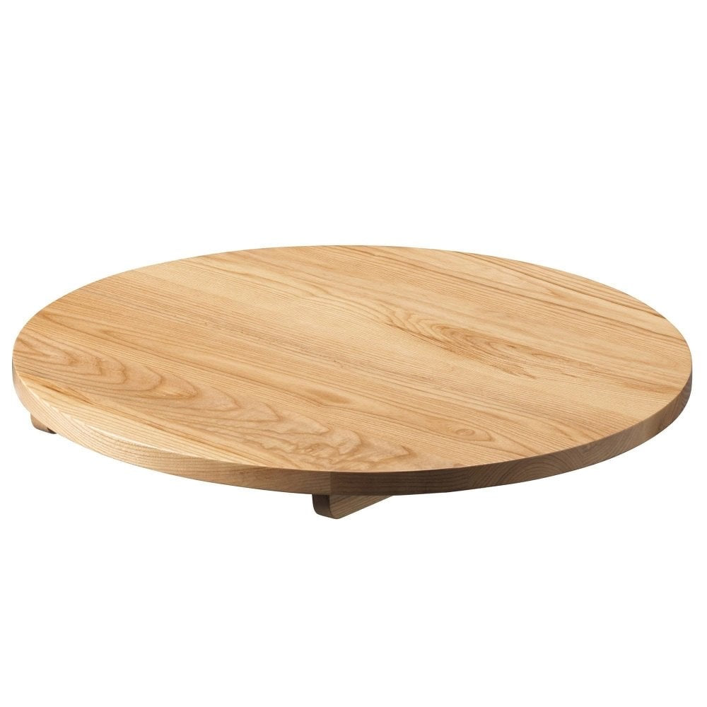 A round, flat wooden turntable tray with a natural light finish is perfect for serving or display on modern dining tables or the Serranto Oak Stain Solid Ash Restaurant Table Top - 25mm, set against a white background.